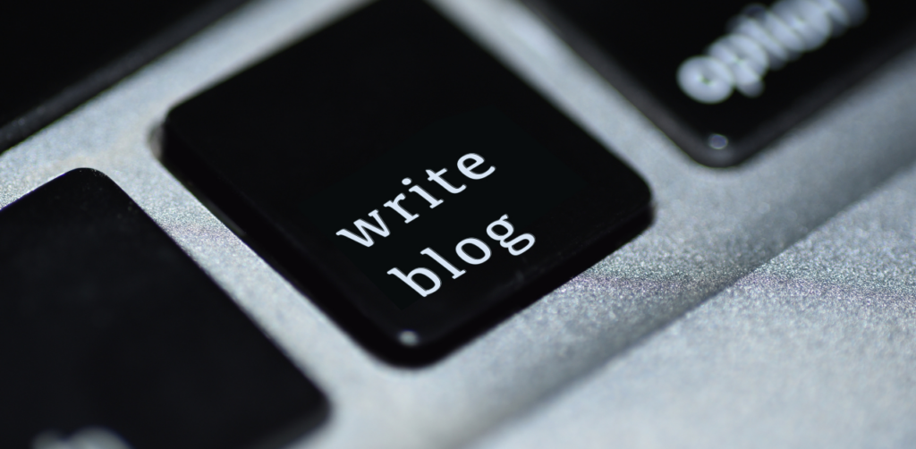 Close-up of a black keyboard key with the words write blog printed in white letters