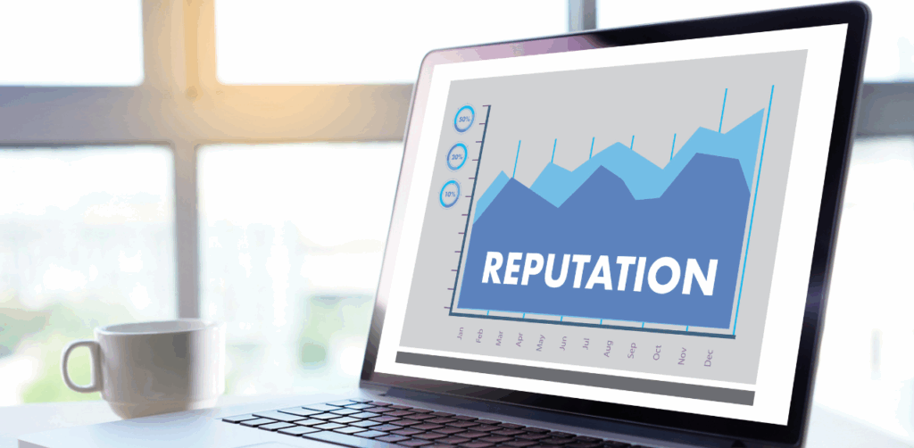 A laptop screen displays a graph labeled “Reputation,” showing fluctuating data across months, symbolizing online reputation management