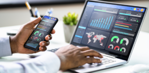 Businessman analyzing marketing analytics on smartphone and laptop
