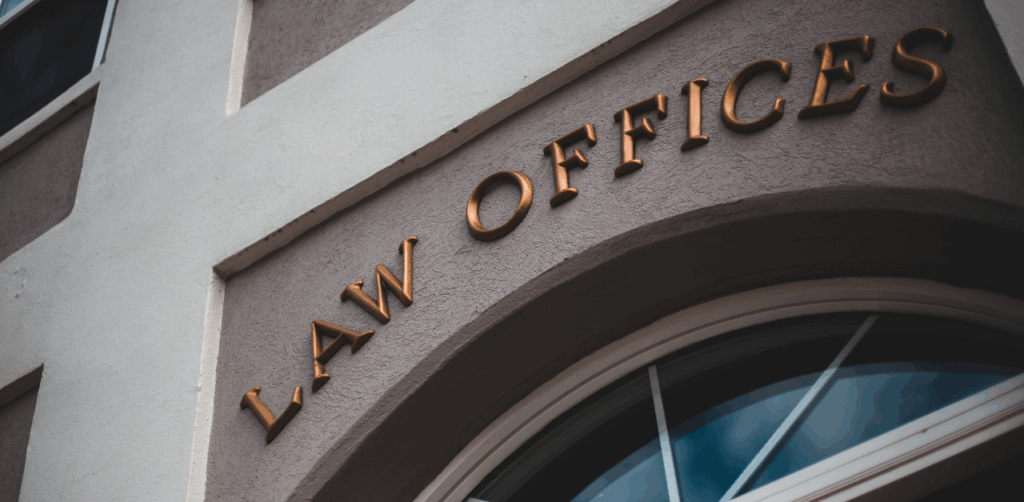 Exterior of a building with bronze “Law Offices” lettering above an arched window