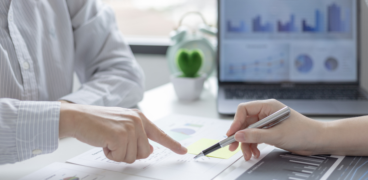Close-up of professionals reviewing financial charts and signing documents during a business consultation
